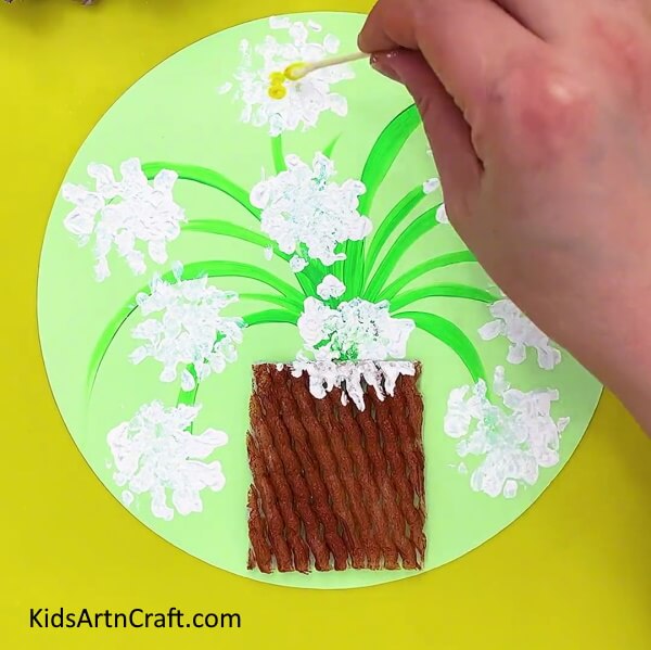Making the center of flower. Procedure for making a Easy Fruit Foam Net Flower Pot Artwork For Kids