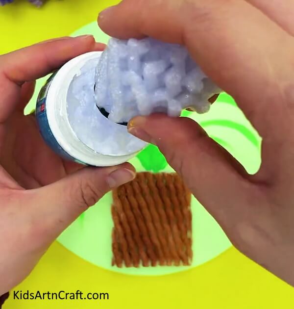 Dipping the roll into paint. Guide tour for Easy Fruit Foam Net Flower Pot Artwork For Beginners