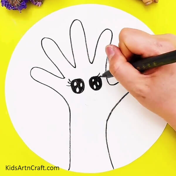 Drawing Eyes For A Tree With The Use Of A Black Pen-Crafting a tree illustration with ease for little ones.