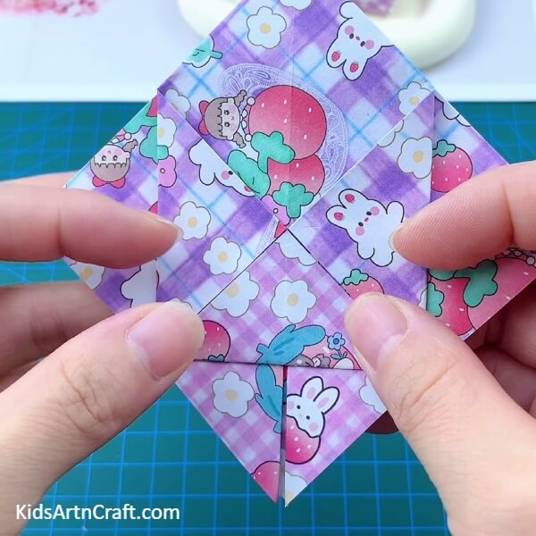 Folding The Bottom Corner-Check out this tutorial to make a miniature origami paper holder