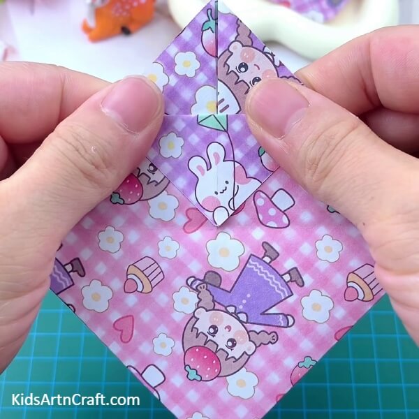 Folding front piece of craft paper some inches- This tutorial provides children with an easy way to make a Paper Basket Origami.