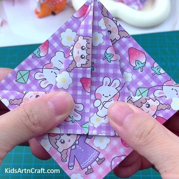 Folding both sides of paper into the middle of the craft paper- Follow the steps in this guide to make a Paper Basket Origami with ease.