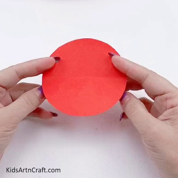 Cutting Medium Size Circles From Red Craft Paper-