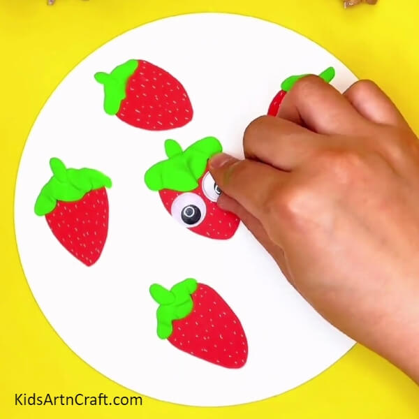 Pasting Googly Eyes- Detailed Guide to Crafting Strawberries with Children 