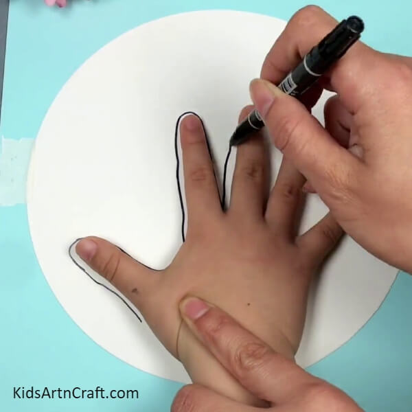 Outlining The Hand-Step-by-step instruction guide for children to create a drawing of a hand and a tree