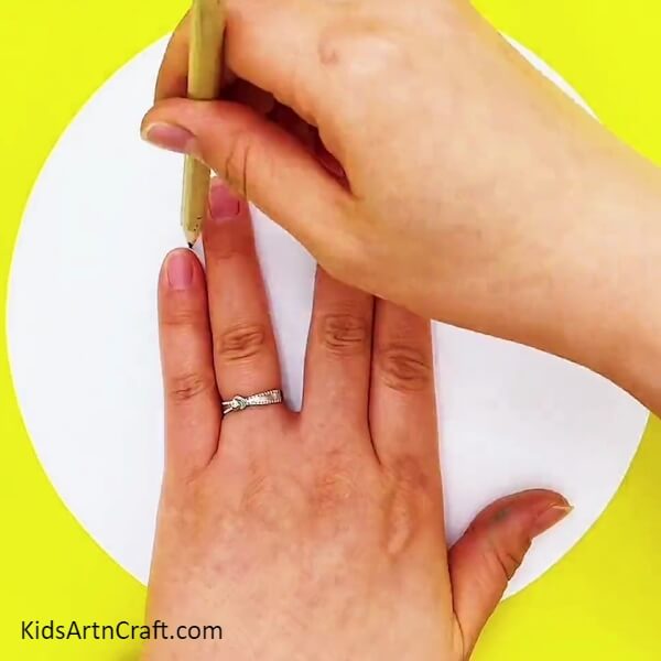 Outlining The Hand Using A Pencil- Step-by-step instructions for children to design a tree with their hands