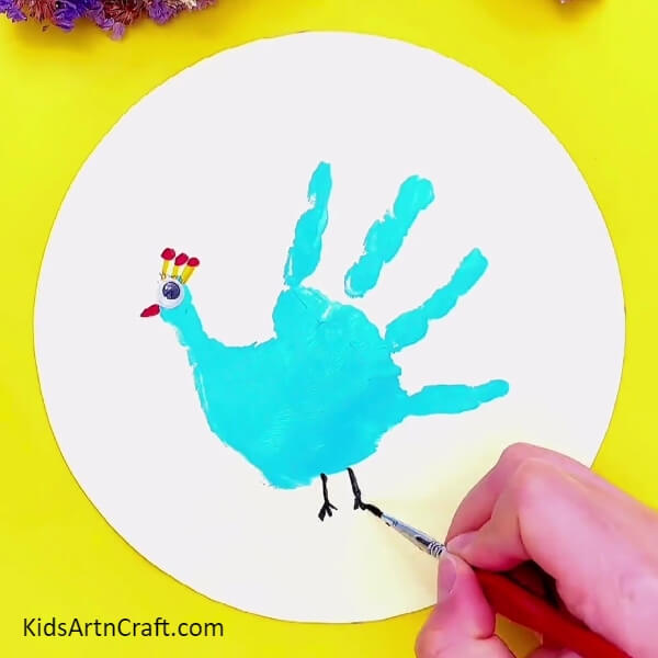 Make The Webbed Feet From Black Paint- A handprint peacock painting project for the novice crafter