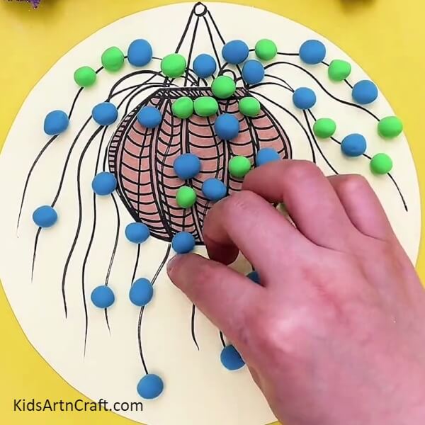 Make Balls From Dark Green Clay And Stick It On Wavy Lines- Teaching Kids to Craft a Hanging Plant Pot 