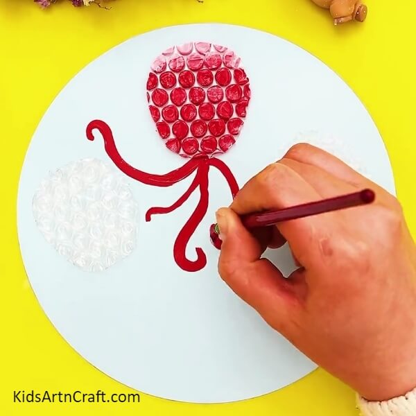 Painting Tentacles For Our First Octopus Using Red Color Paint- A guide to creating an octopus with bubble wrap for kids