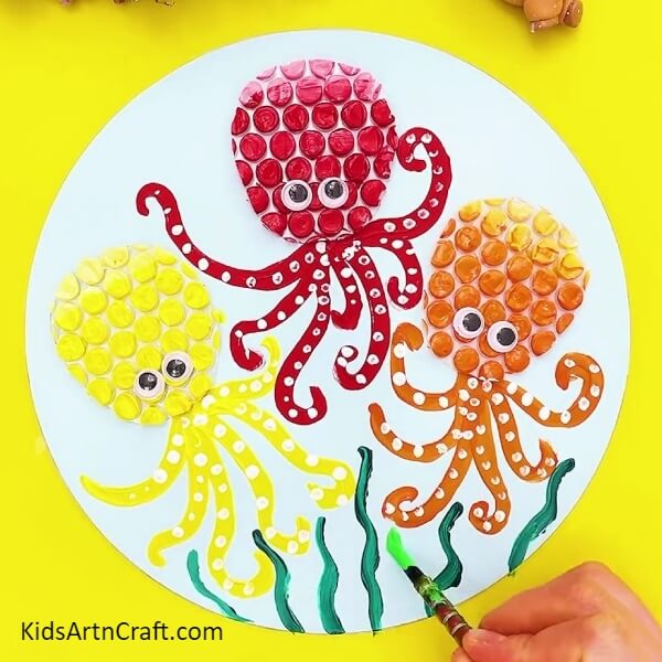 Painting Grass With Light And Dark Green Color Paints-Tutorial for constructing an octopus craft with bubble wrap for kids