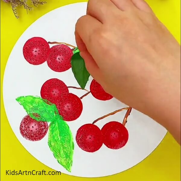 Stamping some leaves on the sheet- Crafting a Step by Step Picture of Sweet Cherries Growing from a Tree 