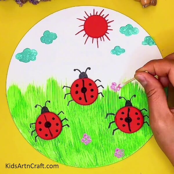 Making The Flowers-An artful clay project featuring a ladybug and garden view