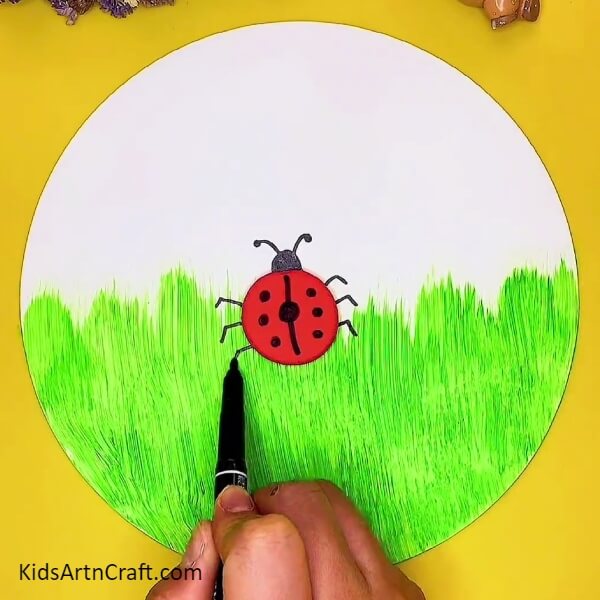 Drawing The Legs Of The Ladybug-An artistic clay concept of a ladybug and garden scenery
