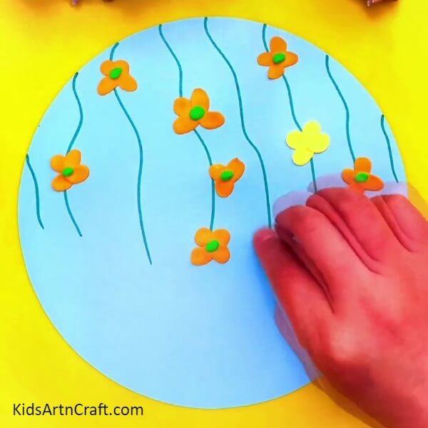 Keep On Making Flowers With Orange And Yellow Modelling Clay-Educate kids on how to form clay butterflies and blooms