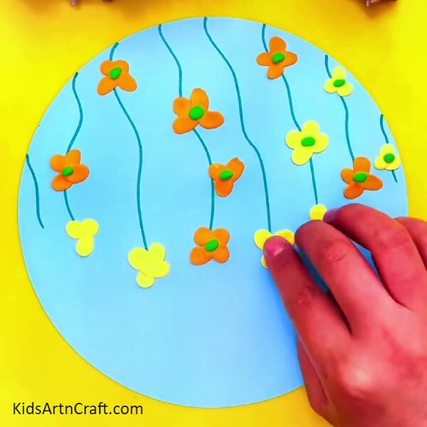 Shape The Clay Into The Shape Of Flowers-Helping young ones to shape clay butterflies and flowers