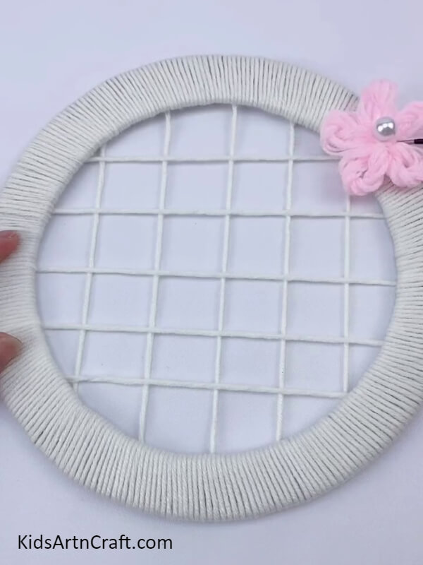Stick the light pink wool flowe- Tutorial to fabricate a wonderful flower wreath with cardboard and wool for youngsters. r on the cardboard