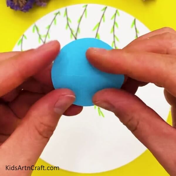 Creasing A Blue Circle Into Half- Detailed Step-by-step Guide For Crafting Paper Birds 