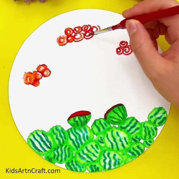 Smudging The Red Spirals With The Paint Brush- A step-by-step tutorial for children to draw a mini watermelon with ants.