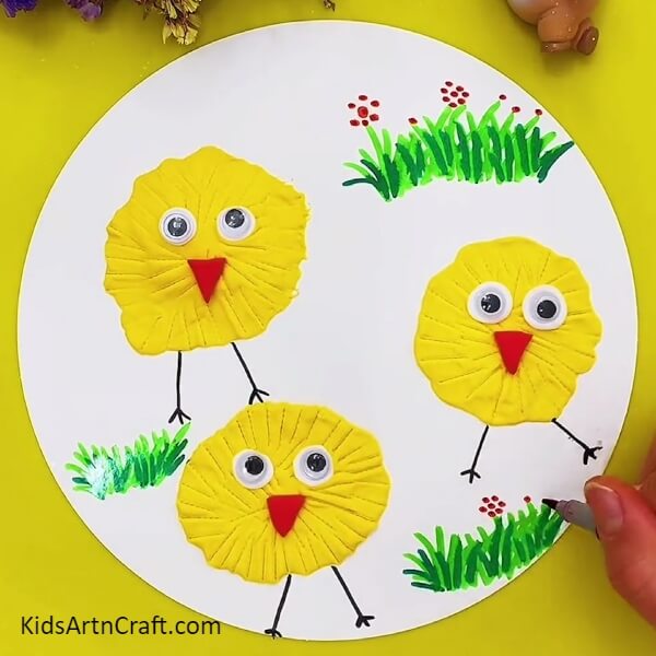 Making Flowers Over The Grass-This Tutorial Gives You Directions to Construct a Clay Chick Craft for Children