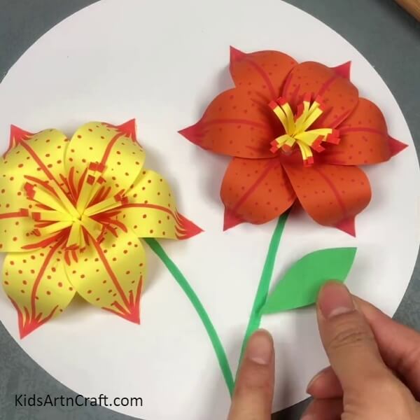 Adding A Leaf To The Stem- This tutorial will teach you how to make a three-dimensional lily out of paper.
