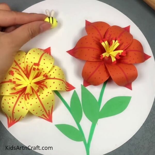 Adding A Bee To The Craft- Step-by-step instructions for constructing a 3D lily out of paper for kids