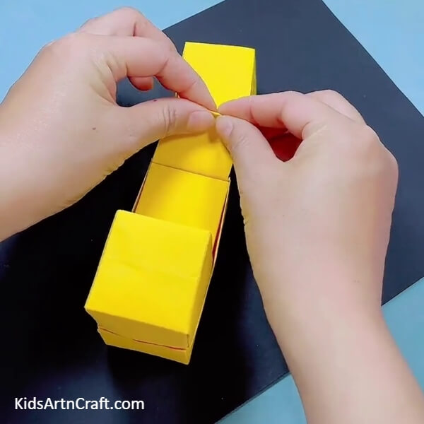 Folding The Strip Into Half- Guide to crafting a Bulldozer from Origami Paper especially for youngsters