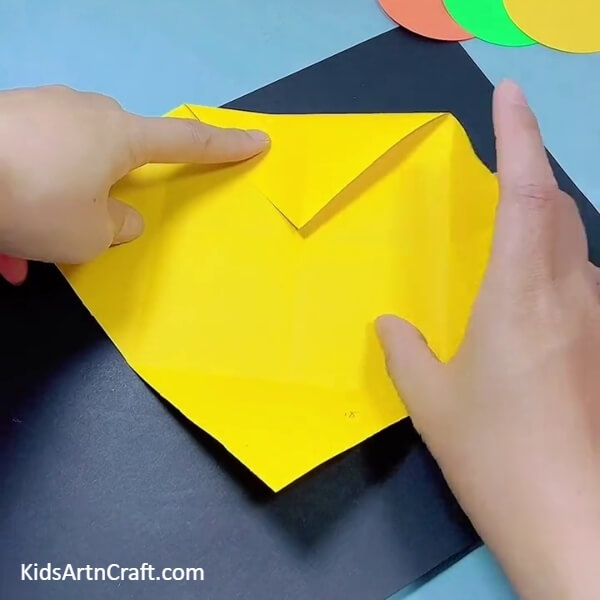 Folding The Corner To the Center- Making a bulldozer from origami paper is easy with this tutorial for kids.