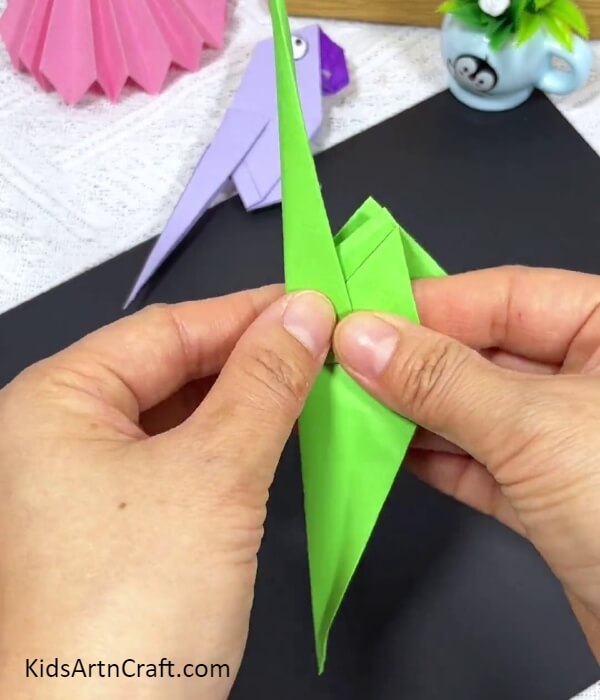 Folding The Figure In Half-Step-by-step instructions for making an origami parrot for youngsters