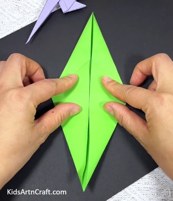 Folding Along The Diamond Creases-Demonstrating origami parrot creations to children