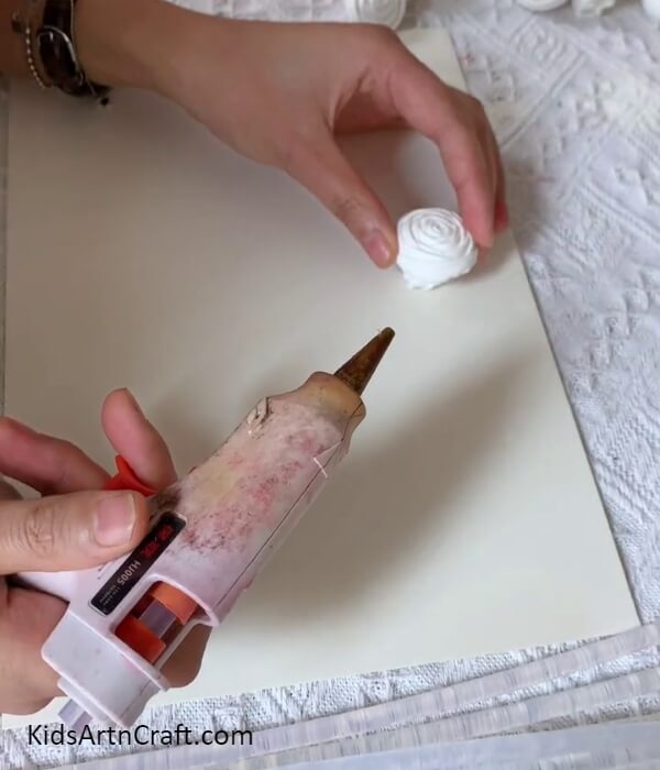 Sticking The Rose Over The Base-Instructions for constructing a framed wall decoration with napkin roses