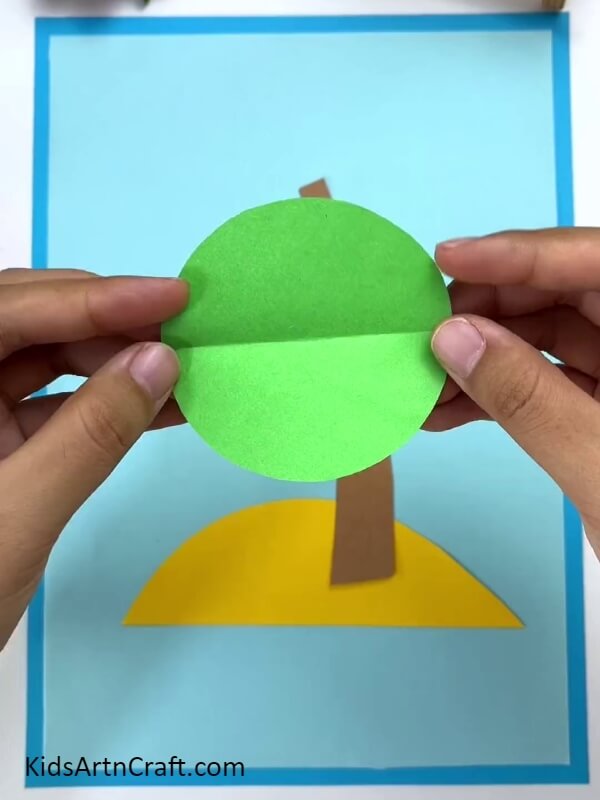 Making A Crease Over Green Circle- Tutorial for creating a paper coconut tree with little ones. 