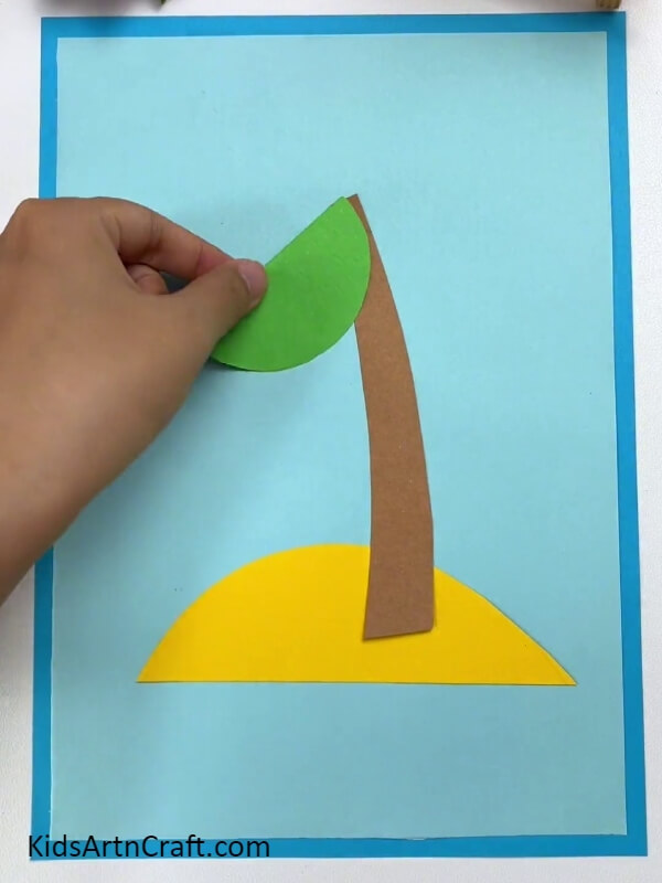 Pasting The Semicircle Leaf- Show children how to assemble a paper coconut tree