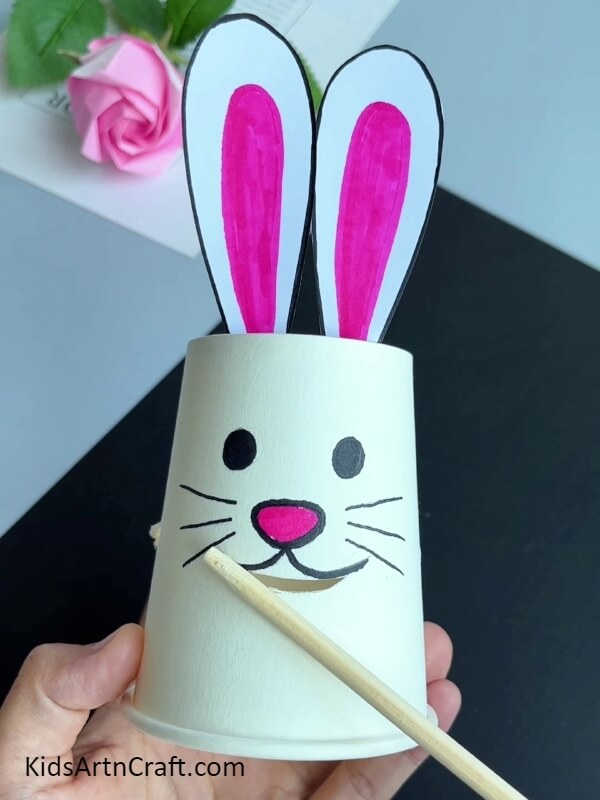 Cutting Out A Smile Of The Bunny- A fun craft for children is to make a paper cup bunny that is eating a carrot.