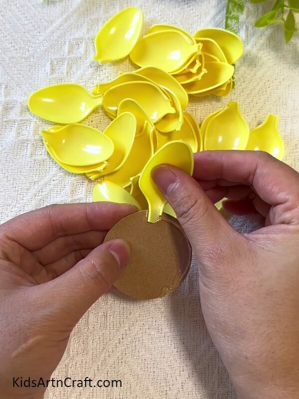 Sticking A Spoon Bowl On The Circle-Kids' Sunflower Art Project with Plastic Spoons 