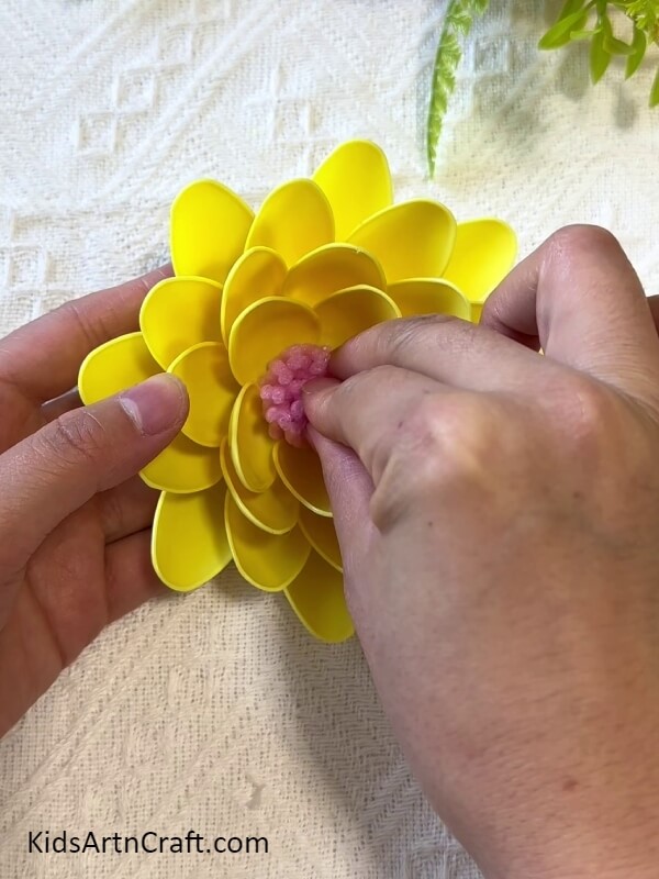 Sticking The Roll To The Center Of The Flower-Kids Can Learn to Construct a Sunflower from Plastic Spoons 