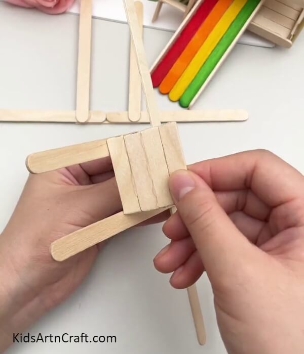 Pasting A Popsicle Stick Square To The Base- Help Children Create a Gliding Model with Popsicle Sticks
