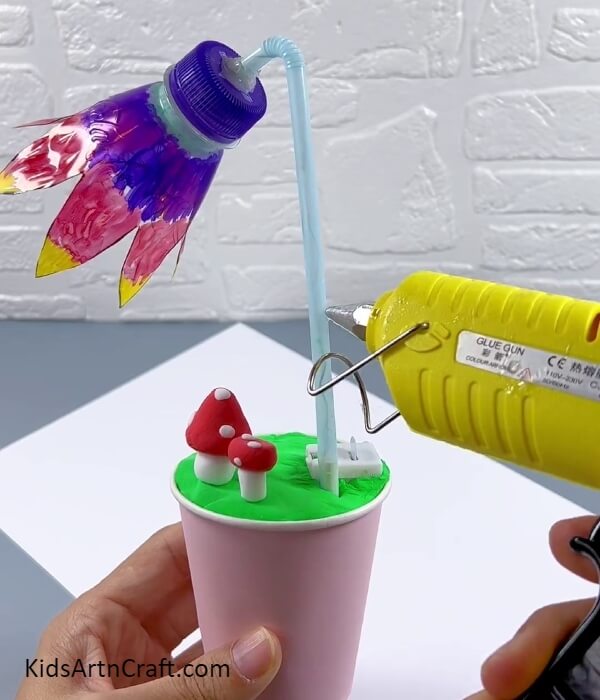 Applying Hot Glue To The Straw- Taking a paper cup and plastic bottle that have been recycled and forming them into a light.
