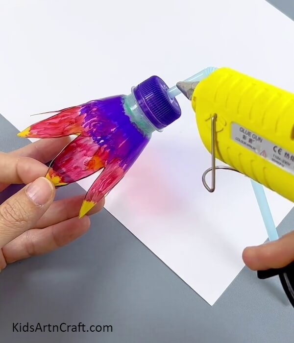 Securing The Straw With Hot Glue- Making a glowing flower using a paper cup and plastic bottle.