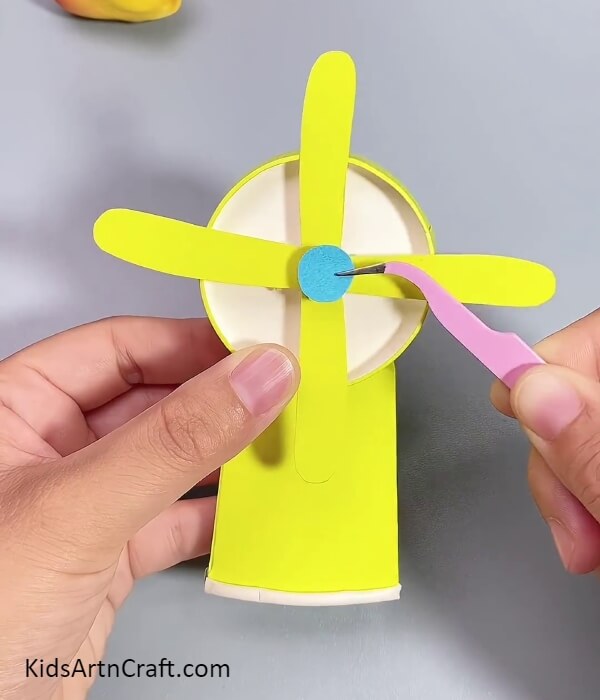 Pasting A Blue Circle- A step-by-step tutorial for kids to construct a fan out of recycled paper cups