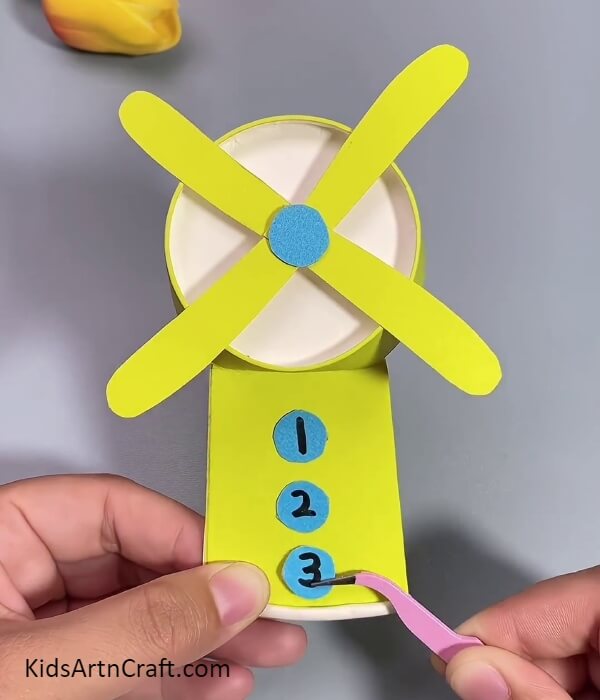 Pasting Numbered Circle- Tutorial For Making A Fan Out Of Recycled Paper Cups For Kids