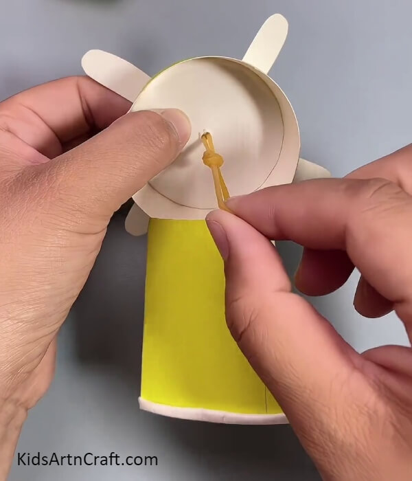 Tieing A Knot Of The Rubber Band- How To Construct A Fan From Repurposed Paper Cups With Children 