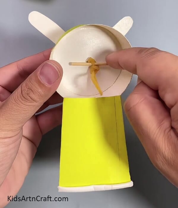 Twisting The Rubber Band From The Stick- Creating A Fan With Used Paper Cups For Kids Step-By-Step Guide