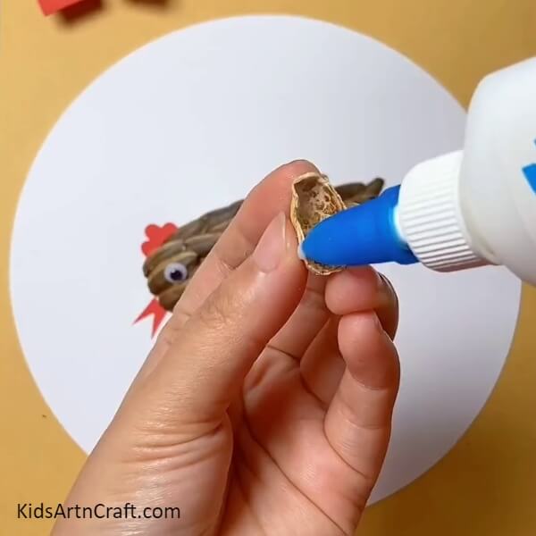 Applying Glue To The Peanut Shell- Sunflower Seeds, Peanut Shells, and Hen & Chicks Craft Guide