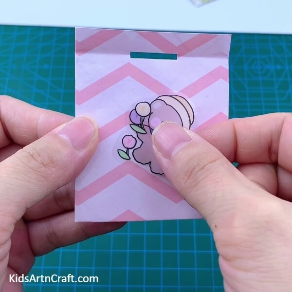 Pasting A Sticker-A Guide to Helping Kids Create an Origami Polybag with Paper